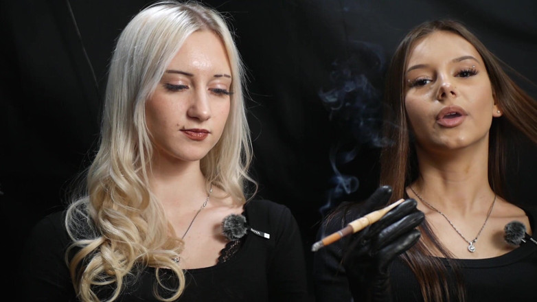 Russian Smokers: Dos mujeres en trajes negros compartiendo un cigarrillo con humo...