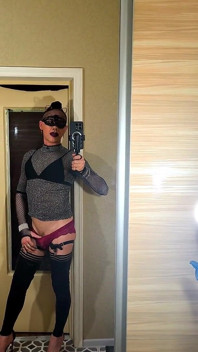 La joven femboy se graba en vídeo frente al espejo, acariciándose el clítoris con bragas rojas y tacones altos.