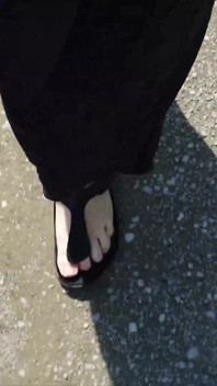 En Plein Air Dans Un Caftan Noir Et Pieds Nus En Birkenstocks Noirs