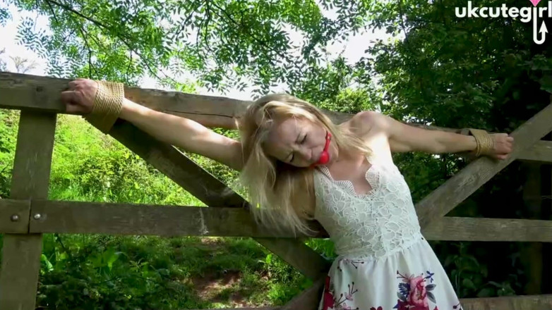 UKCuteGirl Lucy Lauren: Donzella legata al crocifisso a porta bondage e ballgagged