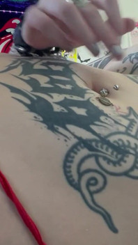 Goth dívka si prstí břicho a hraje si s piercingem na pupek