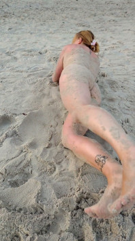 POV. Vous regardez comme un modèle à forte poitrine, de votre présence, se déshabille sur la plage, se baigne et joue sur le sable.