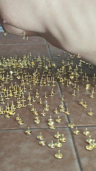 画鋲の上に横たわってオーガズムを迎えるマゾヒスティックな奴隷