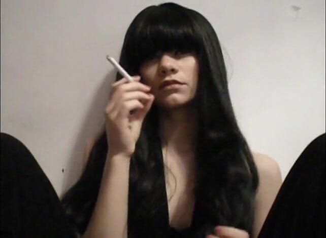 Femdom Austria: Une salope aux cheveux longs fume une cigarette