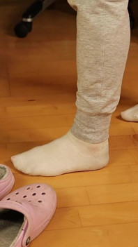 Schmutzige weiße socken - baumeln und fuß necken in trainingshose