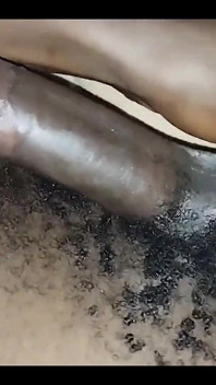 Une amatrice noire branle une bite noire poilue huilée dans un gros plan en solo
