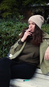 Young Brunette Is Taking an Unhurried Stroll with Allwhite 120mm Cigarette