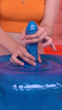 La rossa cavalca uno sgabello blu imbottito con un dildo