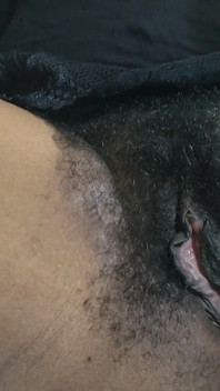 Una milf caliente y un coño peludo en primer plano se masturban