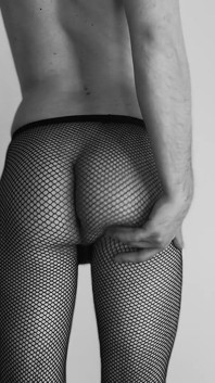 Sexy náctiletý chlapec tančí pouze s škádlením v síťovaných punčochách