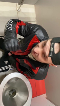 Kinkysirius în costum de Chav Scally suge de la un urs în geacă de piele în toaleta stației