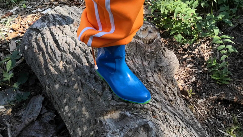 Bouncy Tits Action: Sitting in rubberboots on woodpile
