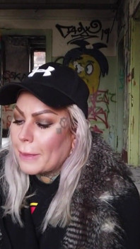 Blonde lady smokes an electronic cigarette on stair