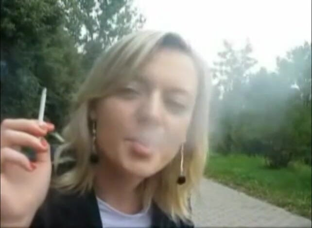 Femdom Austria: Blonde beauty smoking a cigarette outdoors