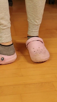 Schmutzige graue Sneakersocken in rosa clogs - lässige fußneckerei