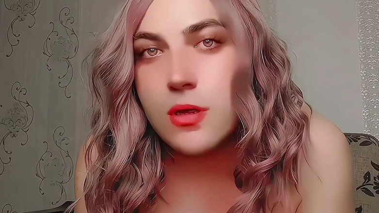 Kitty_Cross: Hravé sissy sedí bokem na velké nadýchané židli