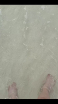 Corndo i miei piedi nudi sulla Sabbia della Spiaggia Bianca in riva all'Oceano
