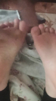 दोस्तों के तलवों के साथ खेलना, जबकि वह पढ़ रही है।