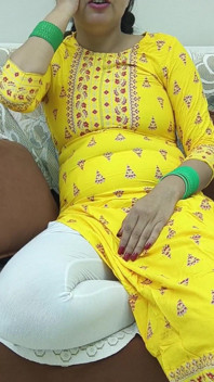 Indiancă desi femeie într-un sari pe o canapea care își expune sânii