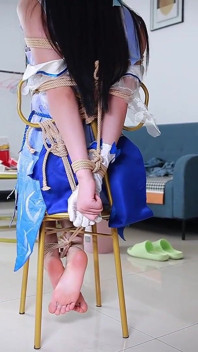 ロープで椅子に快適に座り、足を垂らしている彼女の彼女をコスプレしている