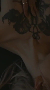 Tattooed teen is dancing in the dark room