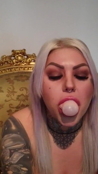 Signora bionda tatuata con una gomma da masticare