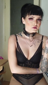 Doamnă gotică tatuată fumând în bucătărie