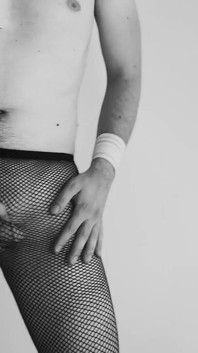 Sexy náctiletý chlapec tančí pouze s škádlením v síťovaných punčochách
