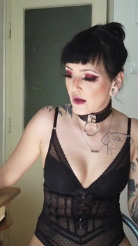 Une femme gothique tatouée fume dans la cuisine
