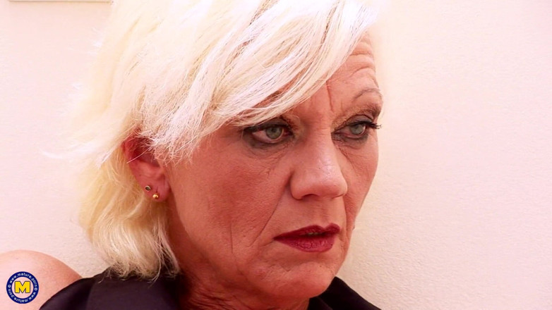 Mature NL: Une femme au foyer excitée regarde à travers un gloryhole