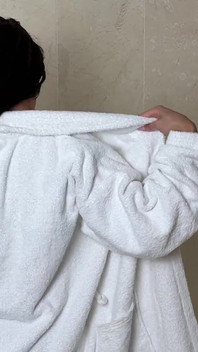 Зріла жінка знімає свій одяг, крім бюстгальтера у ванній кімнаті