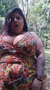 Femeie mare și țâțoasă își expune sânii mari în parc