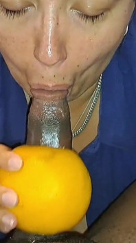 Elle suce une grosse bite noire avec un pamplemousse en le faisant gémir et gémir