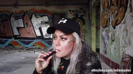 Blonde dame rookt een elektronische sigaret op de trap