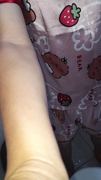 Masturbándose chica en pijamas de satén con pantalones cortos
