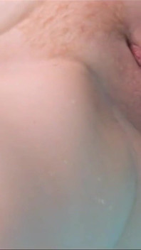 Rödhårig amatör MILF med hårig fitta onanerar med en dildo i poolen