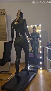 러닝머신에서 포니 힐과 발레 부츠를 신은 개그 라텍스 노예 소녀