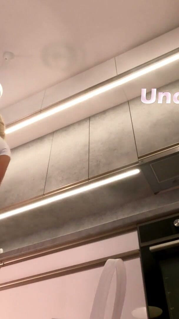 Under Her Skirt: 太いふくらはぎ、ブラなしの大きな胸、自然なブロンドの妻がキッチンでミニスカートの下にパンティを見せている