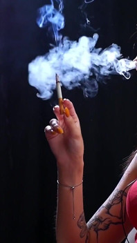 Sexy senhora de vermelho está fumando dois vermelhos 100mm