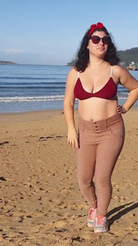 Donna che piscia su una spiaggia pubblica mentre nessuno è lì