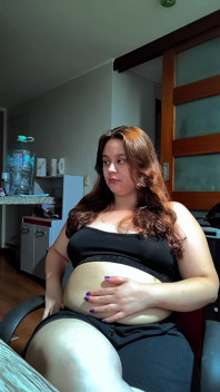 Mujer gordita caliente llenando su vientre redondo con algunos dulces