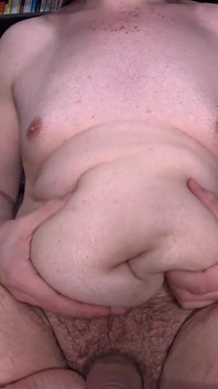 Gordinho esfrega loção por toda a barriga