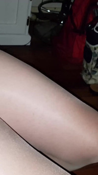 ขาของดานี่ในถุงน่องสีน้ำตาลและรองเท้าส้นสูงสีขาว