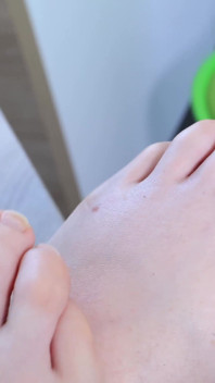 赤毛の女性が自分の痛む足を擦っている