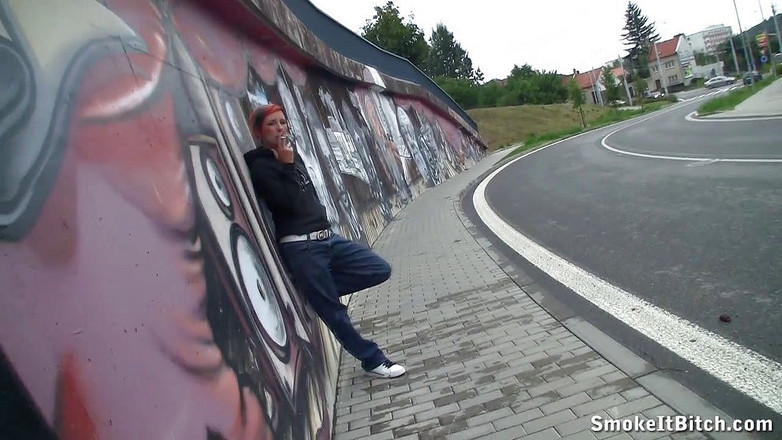 Smoke it bitch: 有色头发和穿孔脸的女孩在街边的人行道上抽雪茄