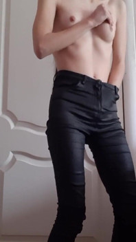 O fată slabă se masturbează în pantaloni de piele