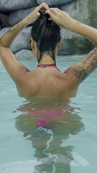 La sexy Monika Fox en bikini rose nage dans la piscine et se promène