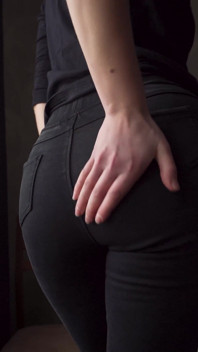 Sexy MILF v těsných černých džínách ukazující bílé tanga velryby ocas