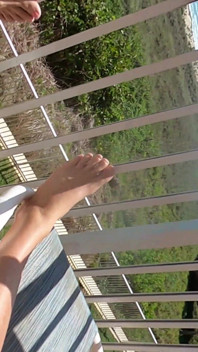 Tomando sol na varanda à vista de todos passando