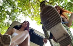 Dos dominatrix en primer plano, dominación de pies y escupiendo doble dominación femenina al aire libre